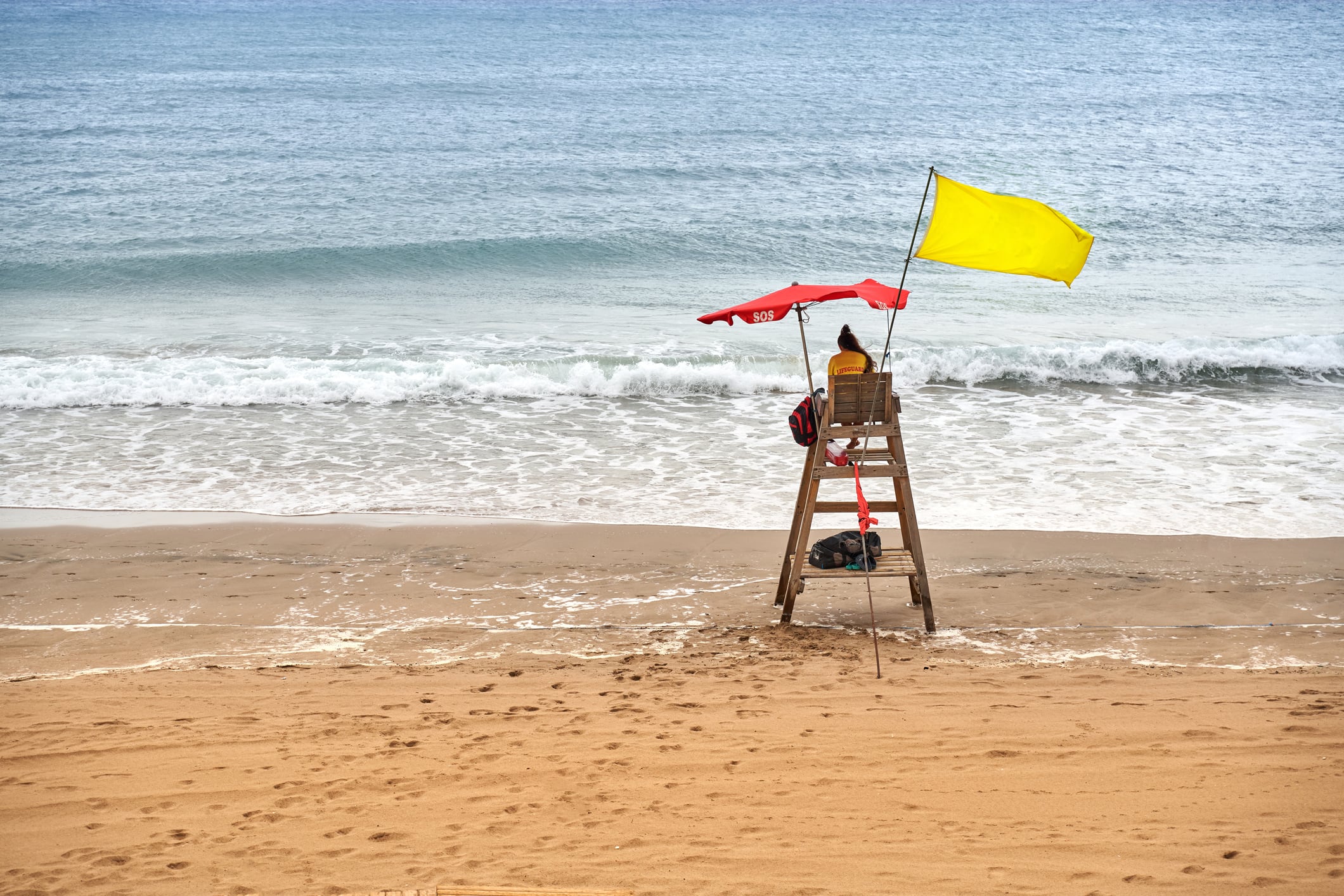 Una bandera amarilla ondea en la playa.