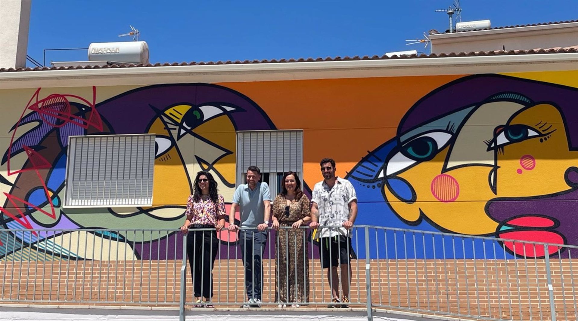 Mural pintado por el jiennense en la Casa de la Igualdad de la localidad de Torreperogil junto a su autor (primero por la derecha), y autoridades de Subdelegación y Ayuntamiento