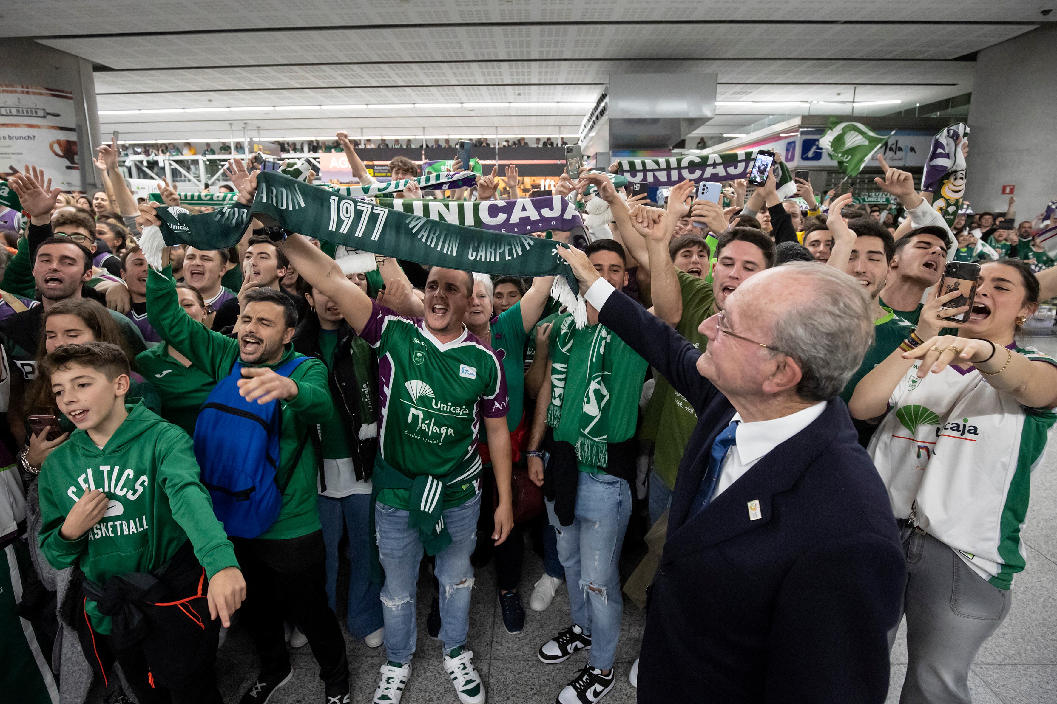 AME6096. MÁLAGA (ESPAÑA), 20/02/2023.- El alcalde de Málaga, Francisco de la Torre, celebra con aficionados de Unicaja hoy en el aeropuerto de la capital malacitana el título de Copa del Rey de baloncesto que han conseguido en la final disputada ayer Domingo frente a Lenovo Tenerife en la pabellón Olímpico de Badalona. El Unicaja culminó en Badalona, ante el Lenovo Tenerife (80-83), su gran obra en la Copa del Rey, que conquistó por segunda vez en su historia tras eliminar en las rondas precedentes al Barça y Real Madrid, un gesta que ningún equipo había hecho nunca en la era ACB. EFE/Daniel Pérez
