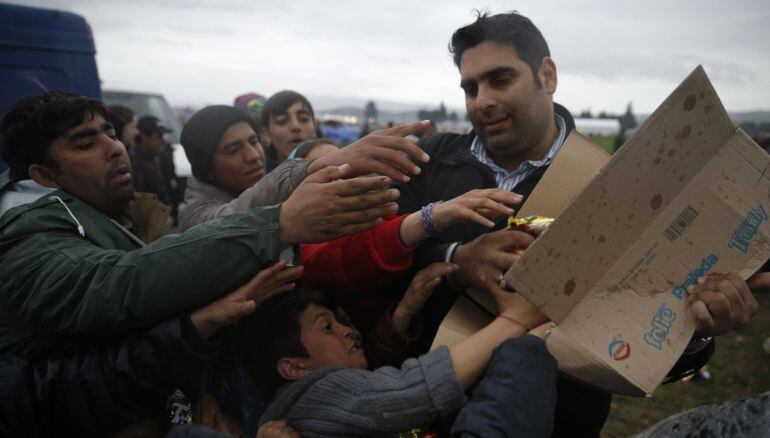 Inmigrantes, que esperaan cruzar la frontera entre Grecia y Macedonia, pelean por comida en un campo provisional cerca de Idomeni 