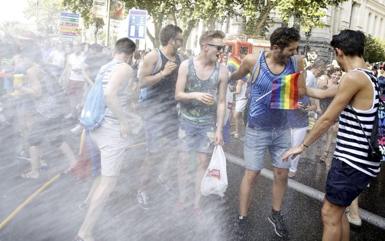 GRA159 MADRID, 04/07/2015.-Bomberos de Madrid refrescan a los participantes del tradicional desfile del Orgullo Gay s durante el recorrido por las calles de Madrid con el lema &quot;Leyes por la igualdad real ¡Ya!&quot;, en una semana en la que se celebra el décimo aniversario de la aprobación de la ley del matrimonio homosexual en España.-EFE/J.J. GUILLEN.