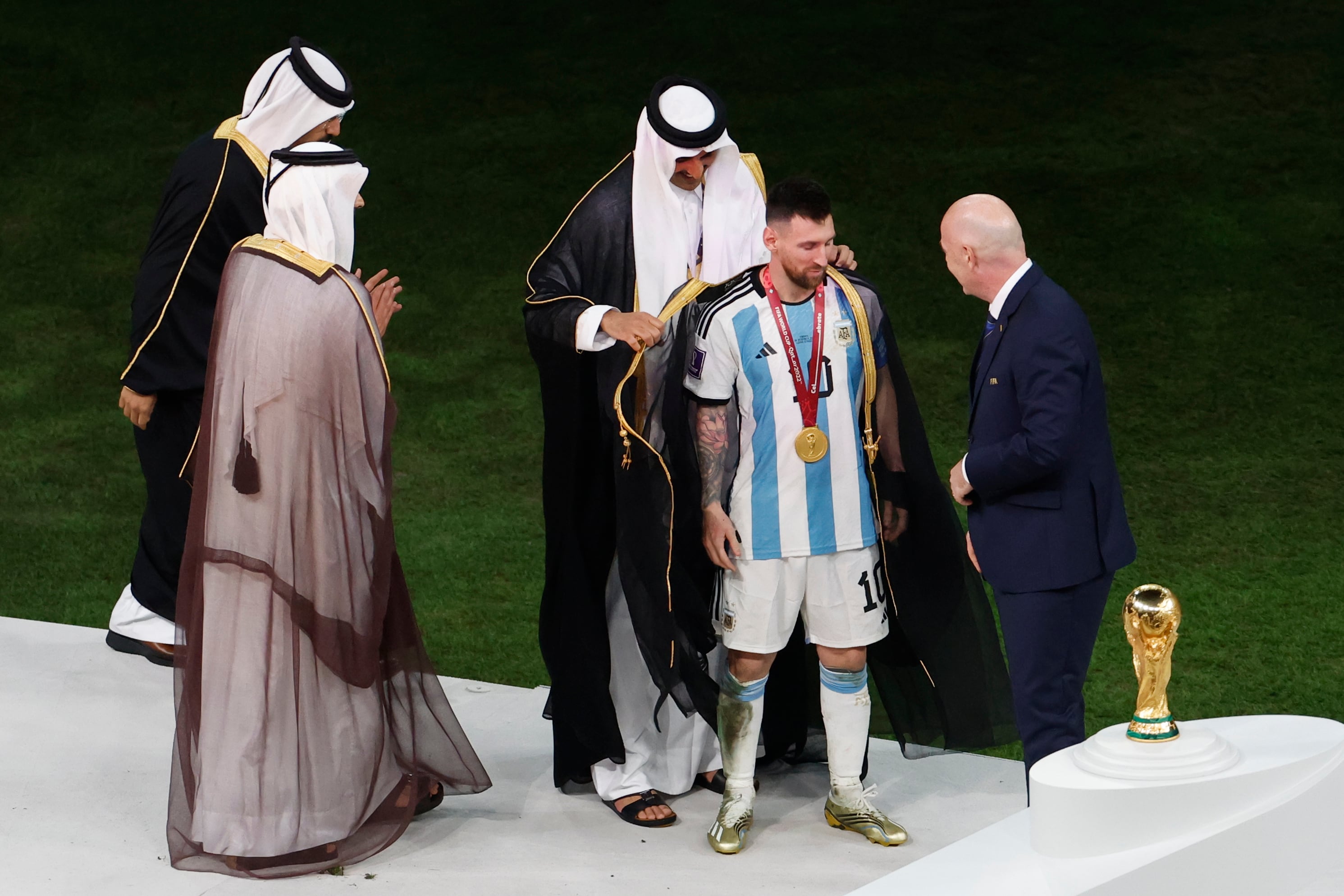 Lionel Messi de Argentina se prepara para recibir el trofeo de la Copa Mundial de Fútbol Qatar 2022 junto presidente de la FIFA, Gianni Infantino, y el emir de Qatar Tamim bin Hamad.