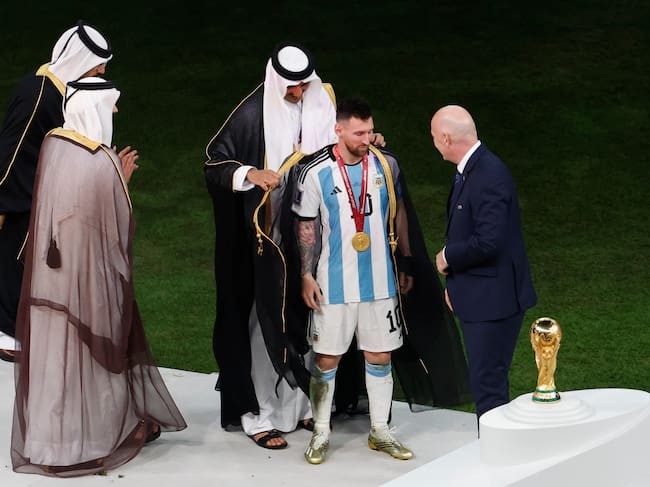 Lionel Messi de Argentina se prepara para recibir el trofeo de la Copa Mundial de Fútbol Qatar 2022 junto presidente de la FIFA, Gianni Infantino, y el emir de Qatar Tamim bin Hamad.