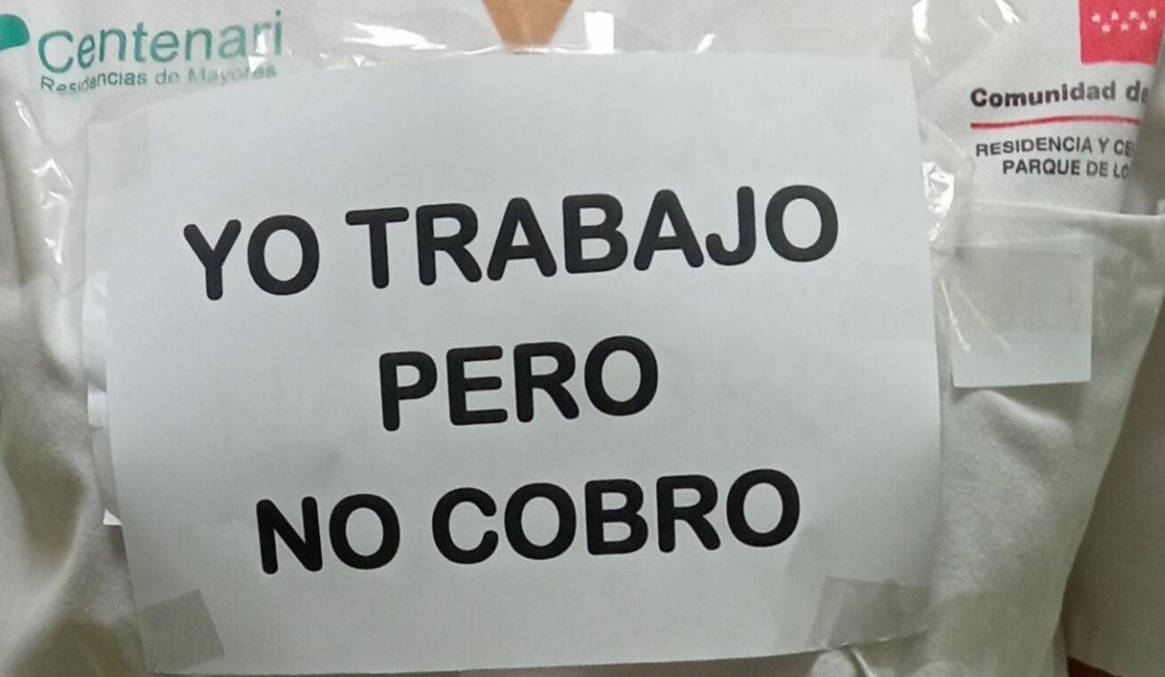 Una trabajadora con un cartel denunciando que le adeudan la paga extraordinaria de Navidad.