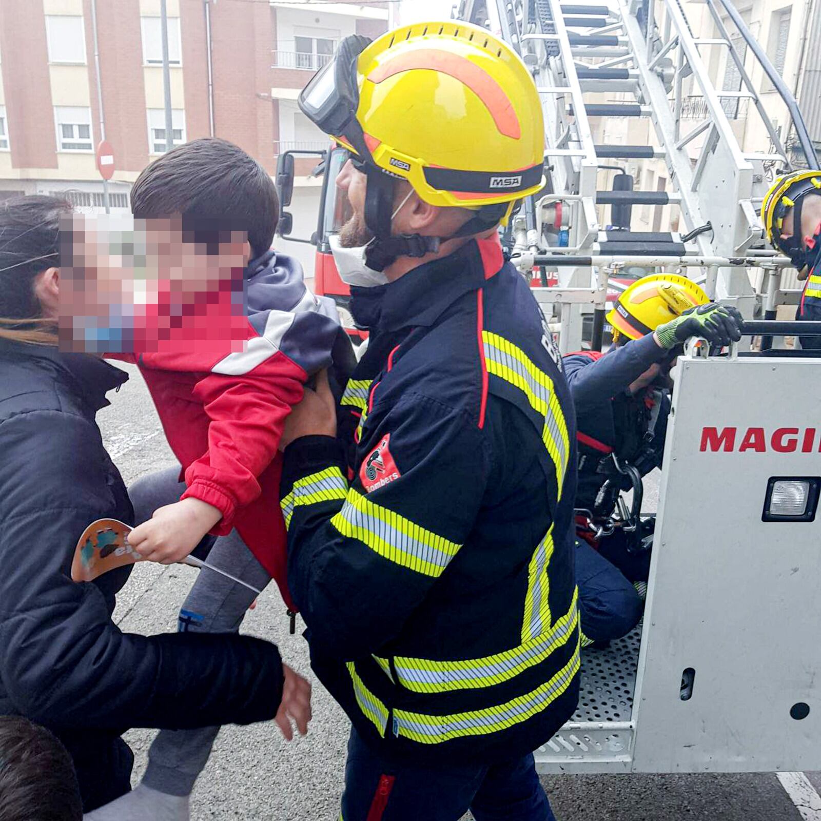 Un bombero del Consorcio de Alicante entrega a un niño de 3 años tras ser rescatado en Banyeres de Mariola