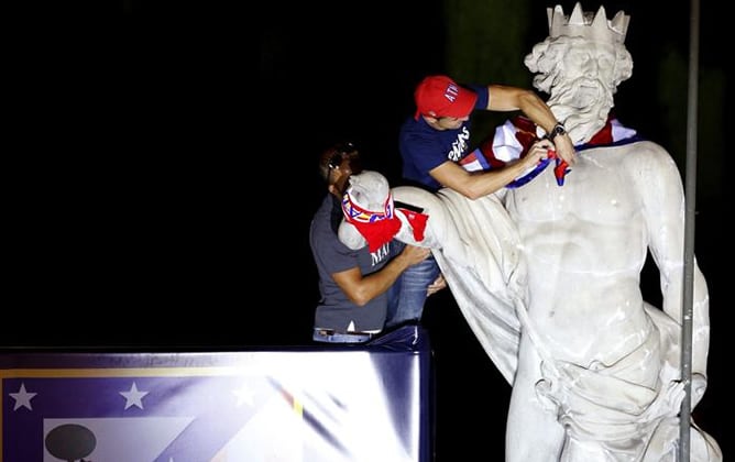 El capitán del Atlético de Madrid Gabi le coloca una bandera rojiblanca a Neptuno durante los actos de celebración de la Supercopa de Europa