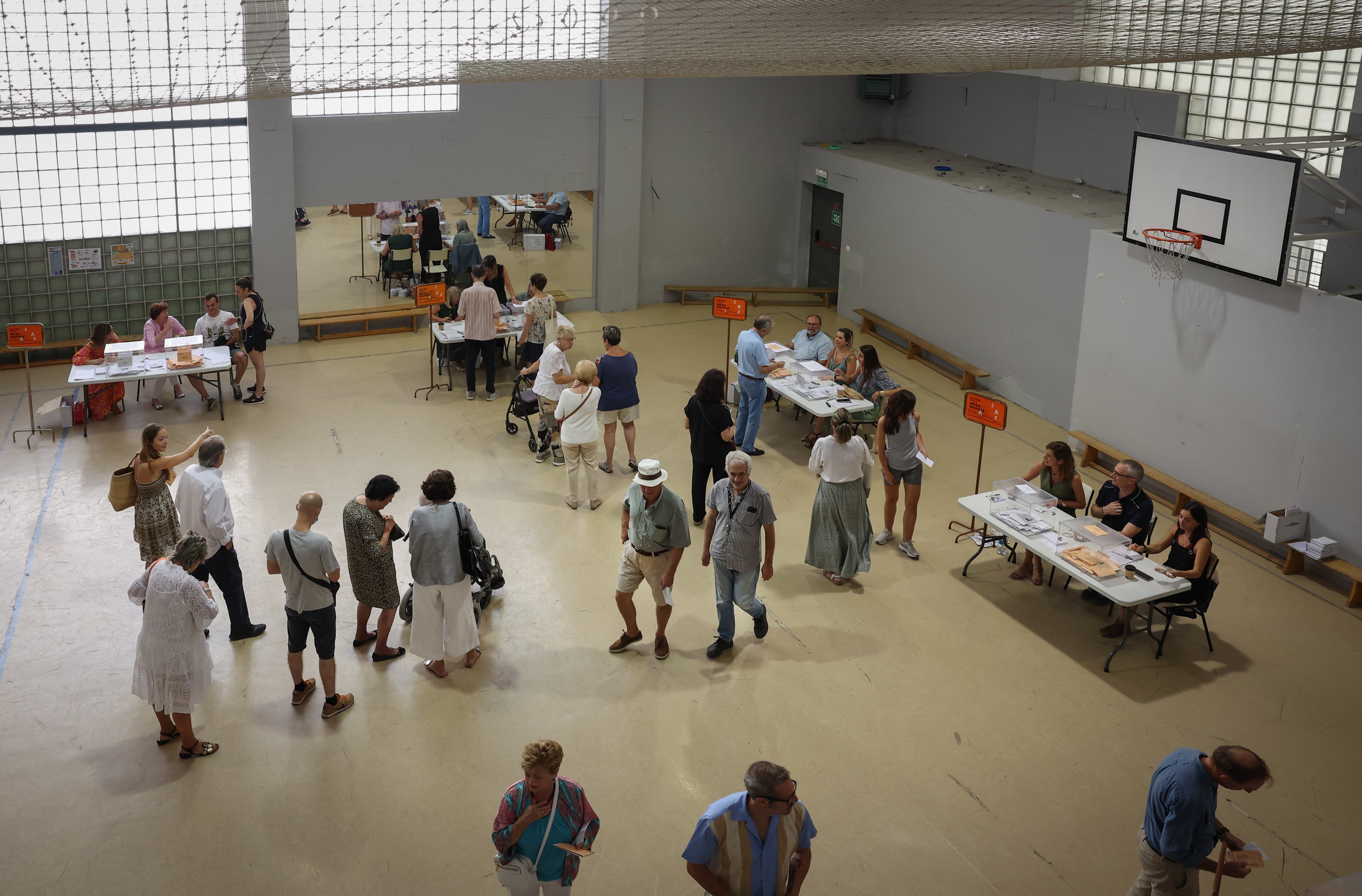 Varias personas ejercen su derecho al voto en un colegio de Pamplona