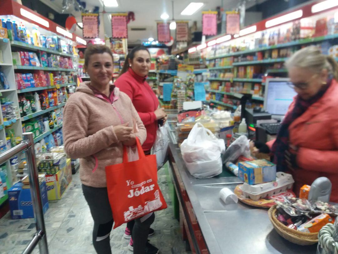 Una vecina recoge su bolsa de compra en Supermercado Alejandro, en la calle General Fresneda