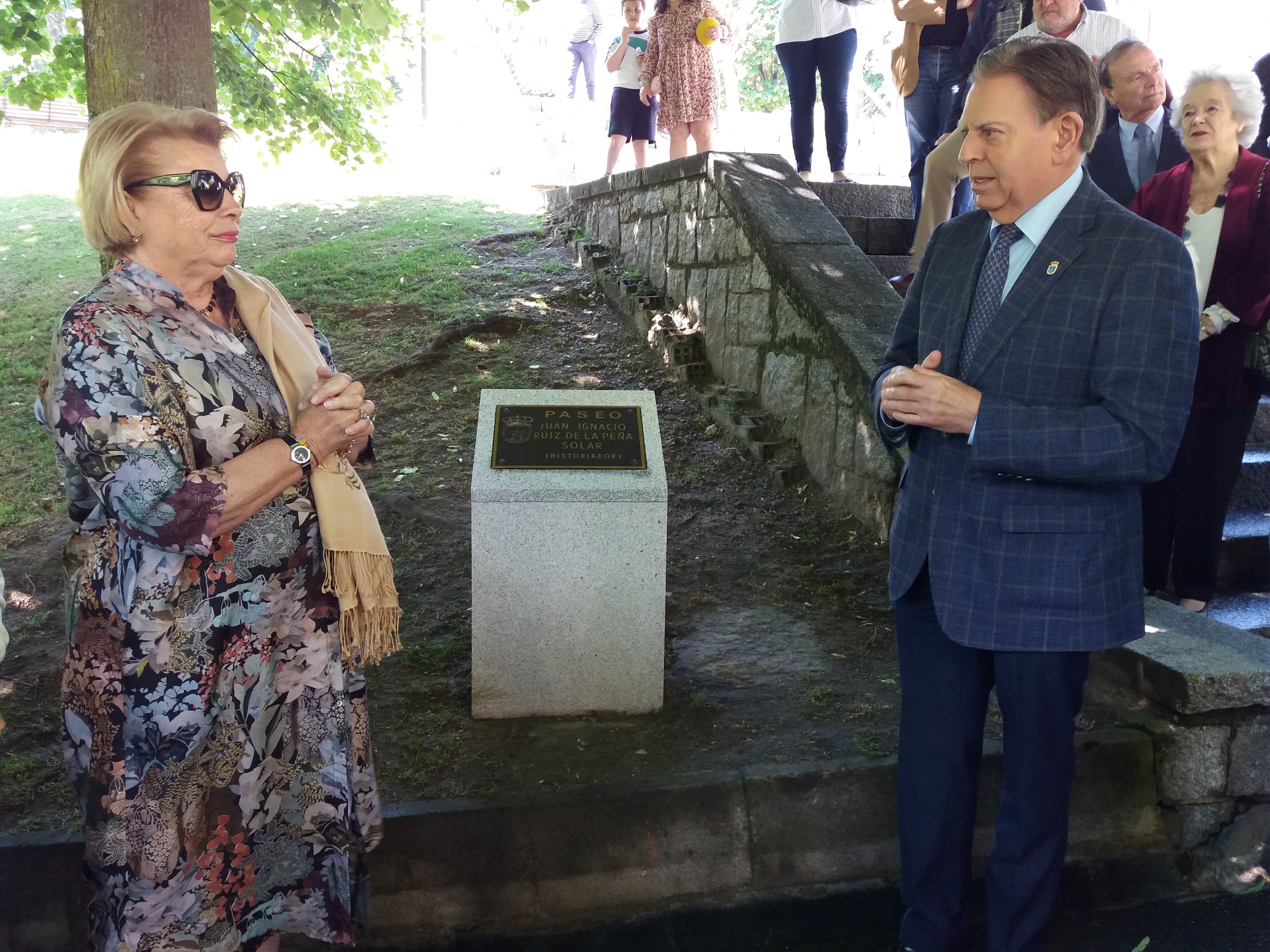 El Alcalde de Oviedo y la viuda del homenajeado charlan junto al monolito que soporta la placa con el nombre del historiador