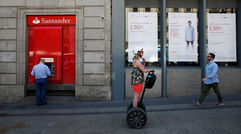 Un cajero del Santander frente a una oficina del Popular