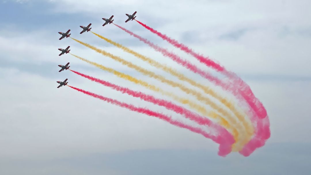 La Patrulla Águila realizando una pasada con la que dibujan la bandera de España en el aire