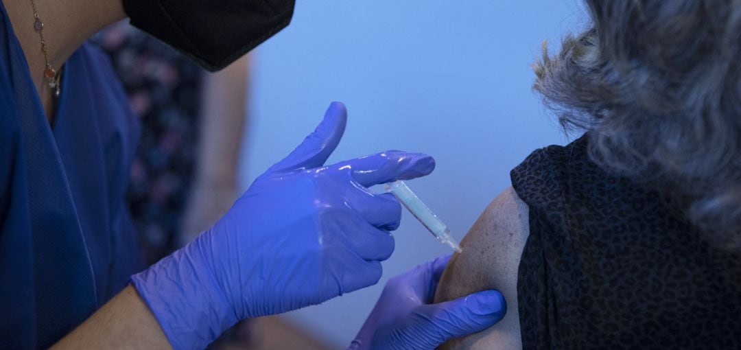 Una sanitaria vacuna a una mujer