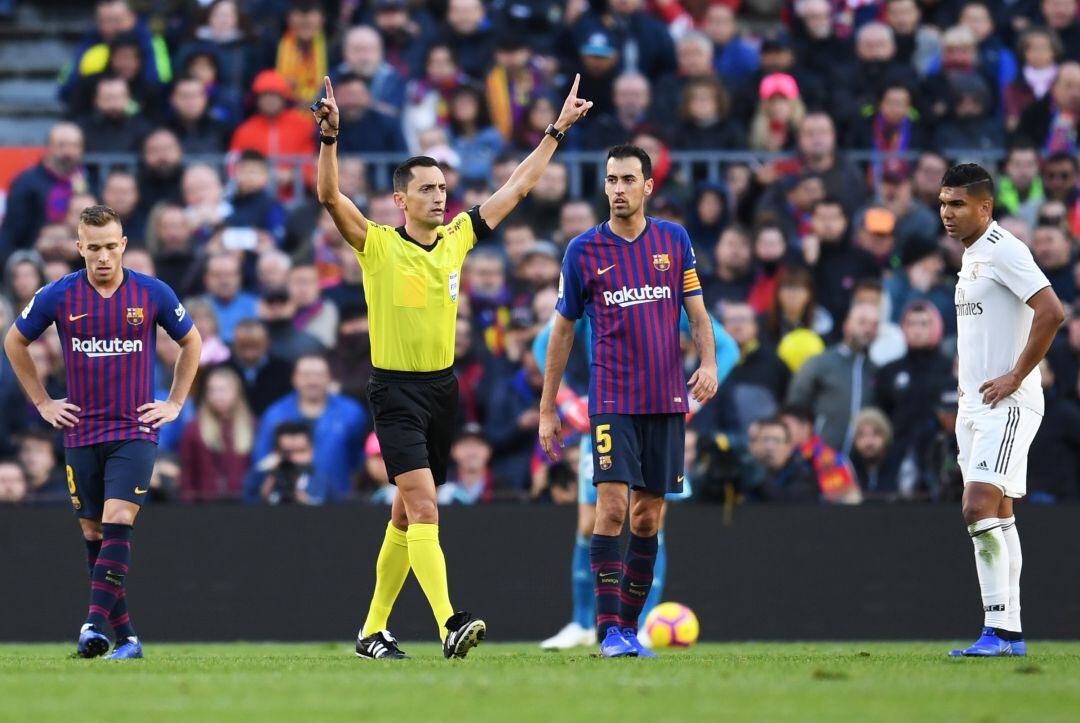 El colegiado pide el VAR durante el Clásico. 