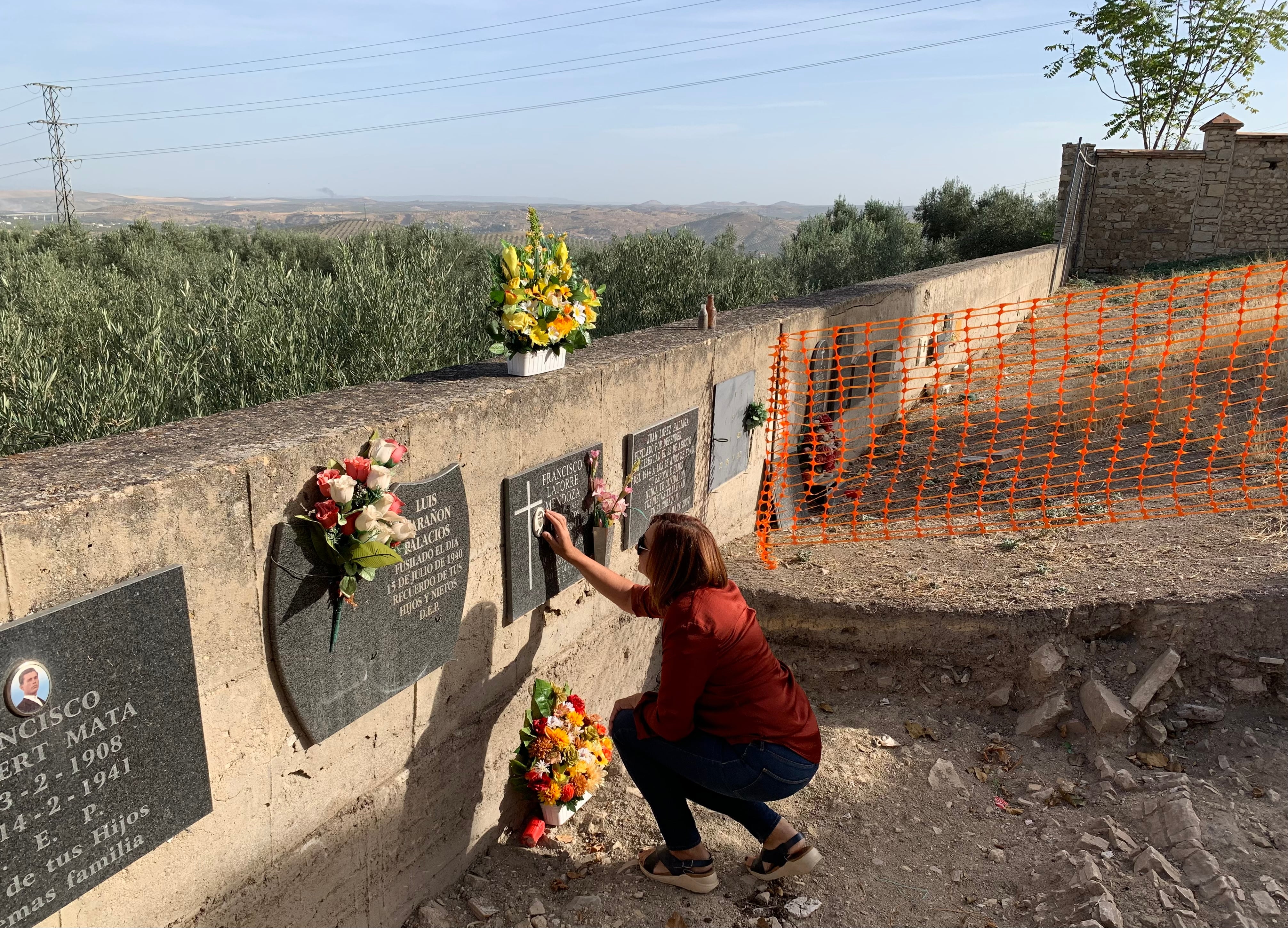 Una mujer, ante la lápida de un familiar en el cementerio de San Eufrasio.