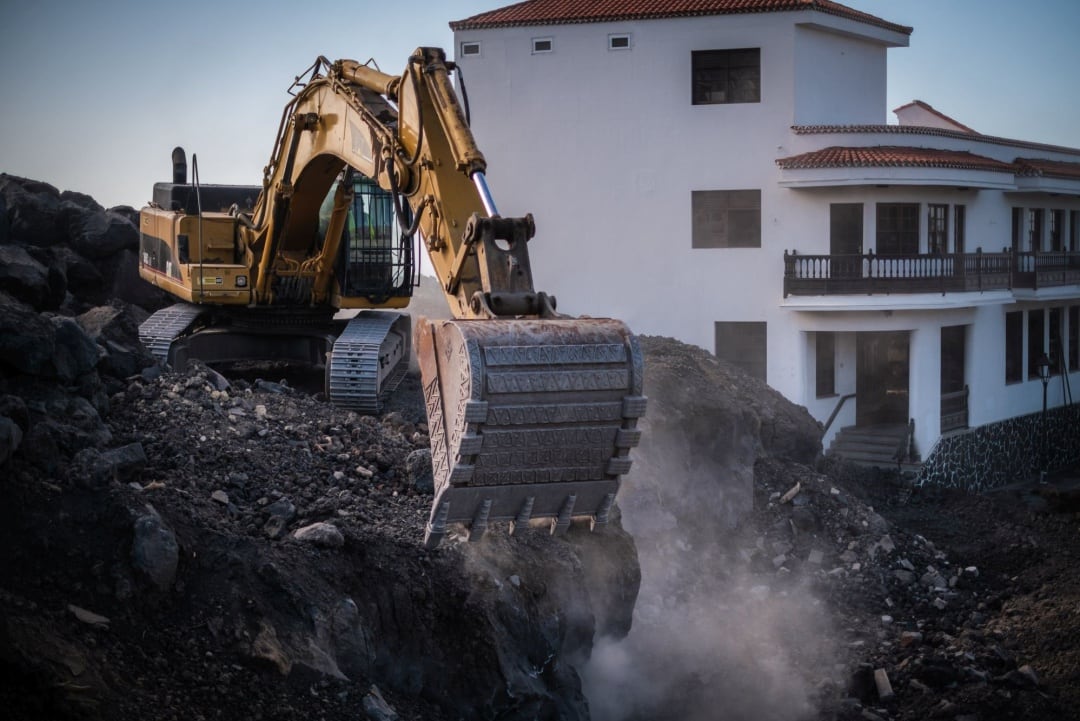 Una pala procede a la retirada de lava en el cruce de La Laguna, en el municipio de Los Llanos de Aridane, en la isla de La Palma, días después de darse por finalizada oficialmente la erupción del volcán 