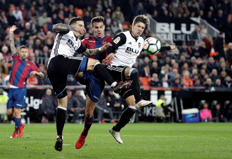 GRAF9502. Valencia, 11022018. Los jugadores del Valencia CF, Santi Mina (i) y el argentino Luciano Vietto (d), disputa un balón con el jugador del Levante UD, Roberto Suárez, durante el encuentro correspondiente a la jornada 23 de primera división que dis