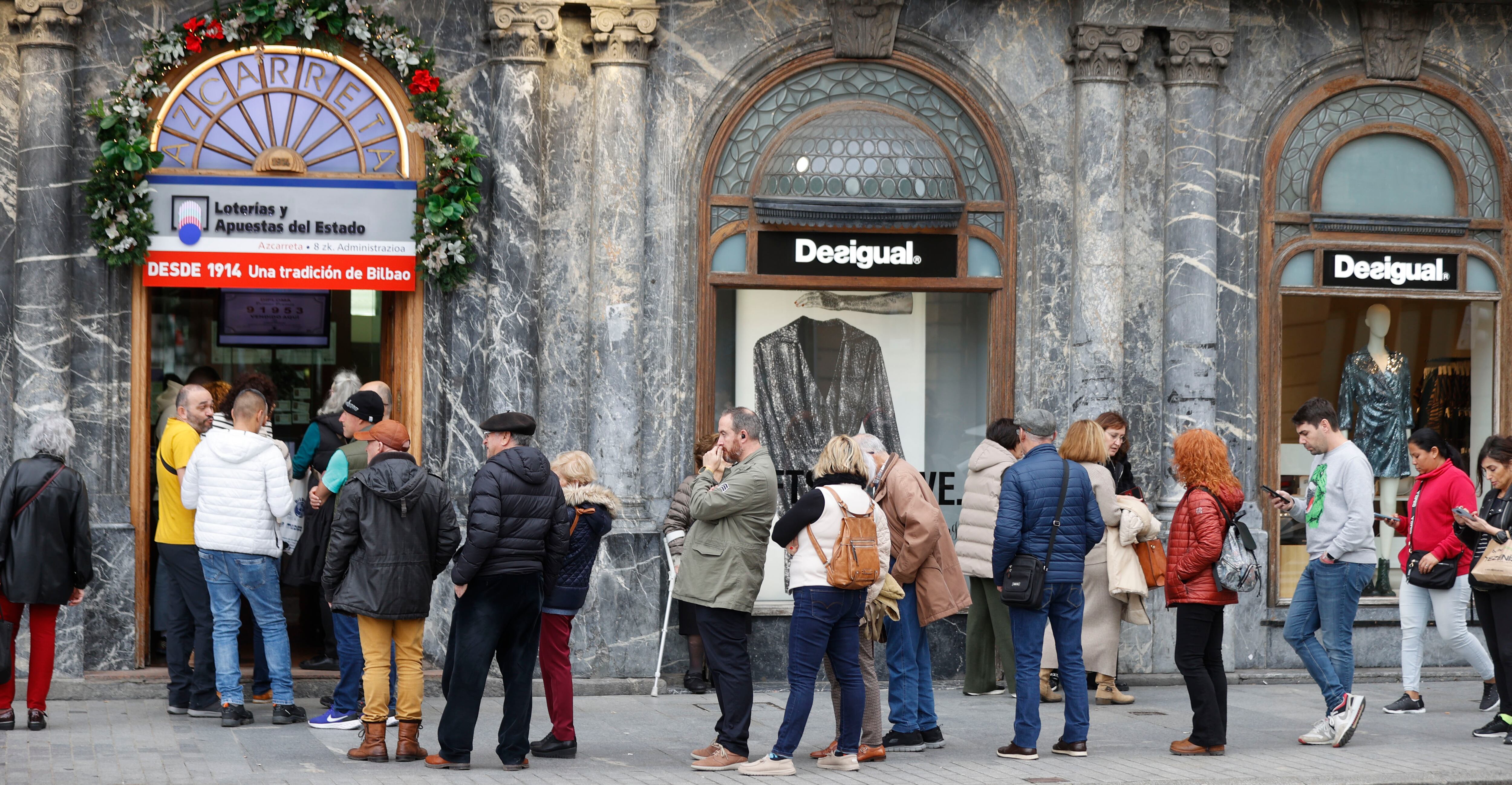 GRAFCAV6921. BILBAO, 11/12/2023.-Colas para comprar décimos de lotería para navidad este lunes en el arenal bilbaíno, un clásico cuando se acerca la temporada navideña. EFE/Luis Tejido
