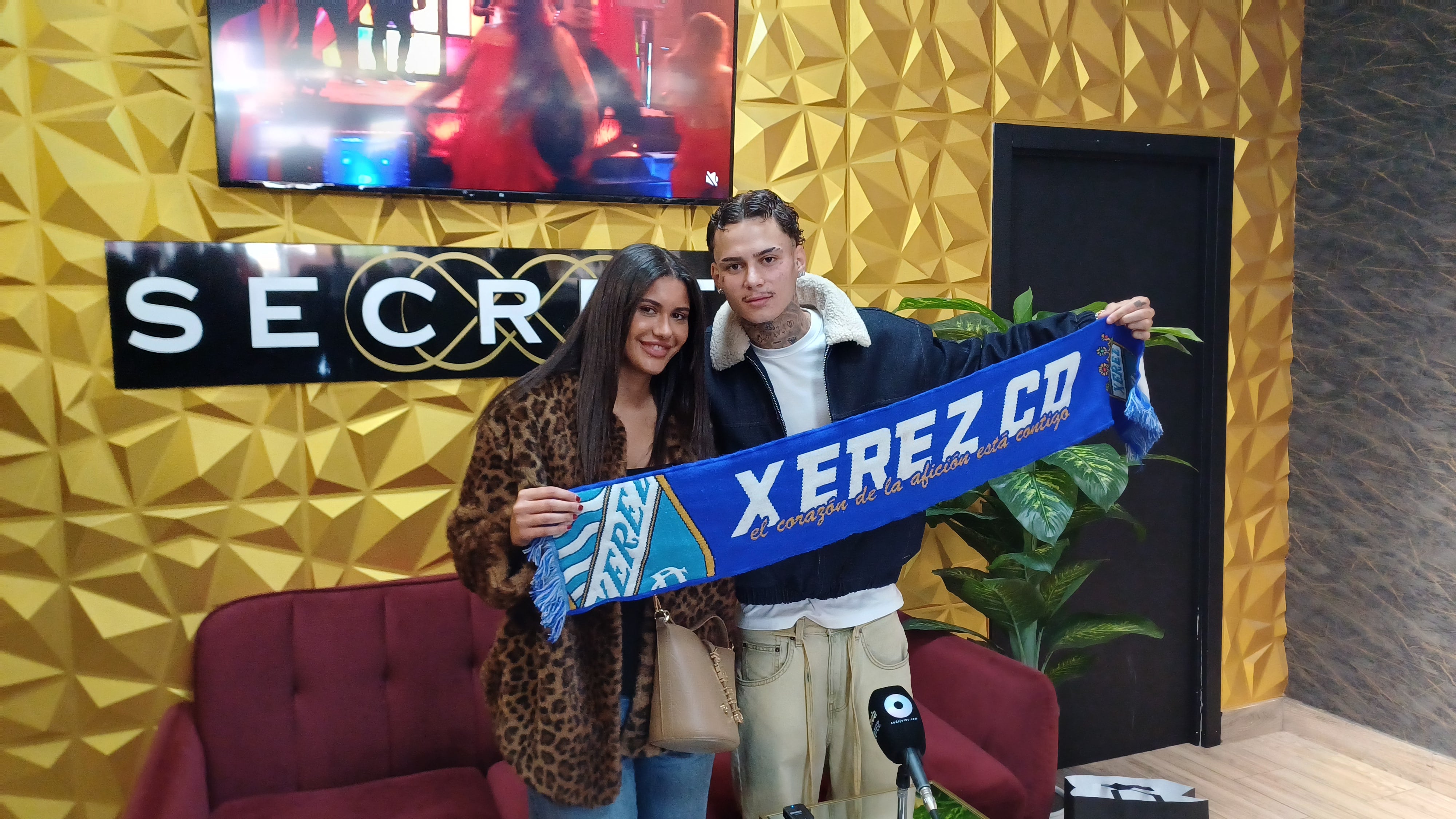 Joel Domínguez posando con la bufanda del Xerez CD junto a su pareja