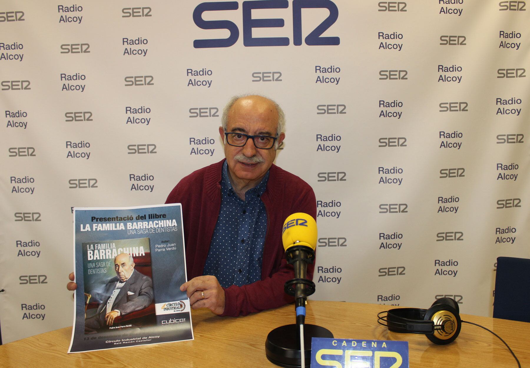 Pedro Juan Parra sostiene un cartel que anuncia la presentación del libro