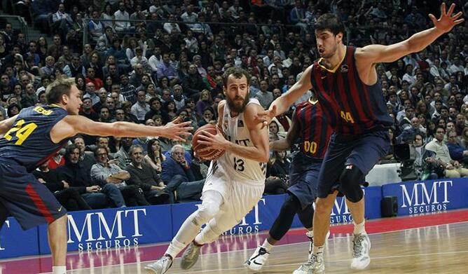 El base del Real Madrid Sergio Rodríguez entra a canasta ante los jugadores del F.C. Barcelona Ante Tomic y Brad Oleson, durante el partido correspondiente a la decimotercera jornada de Liga ACB.