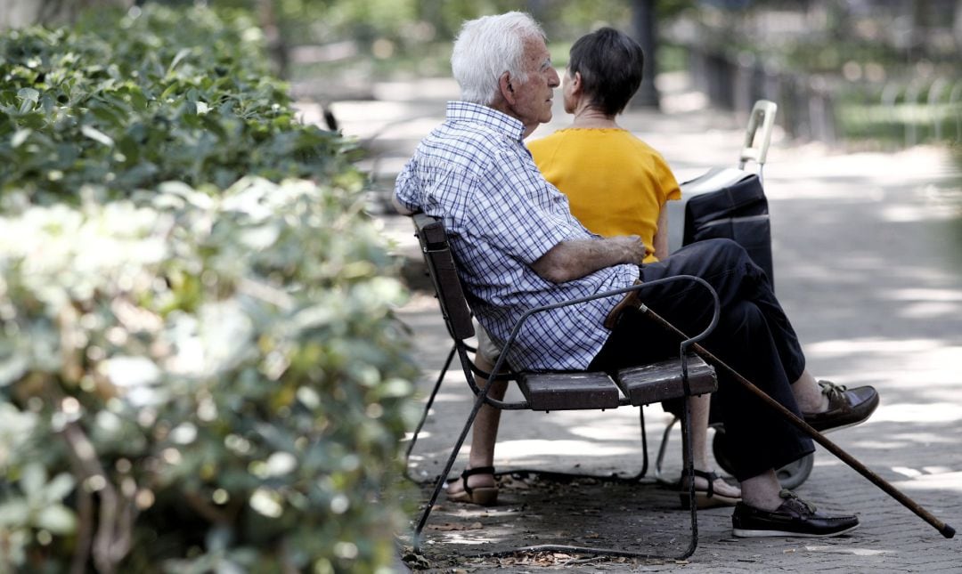 Un pensionista descansa en un banco de un parque de Madrid.