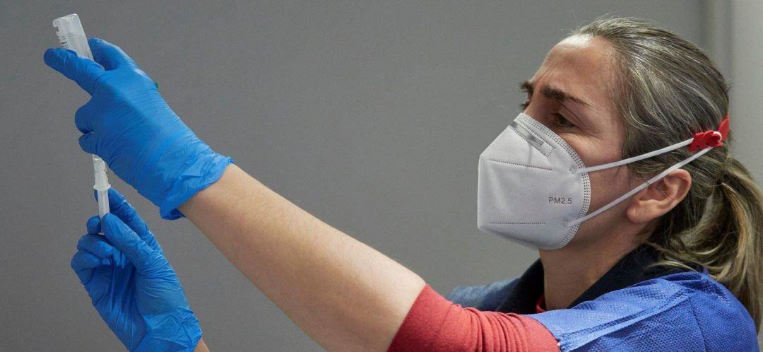 Una trabajadora sanitaria administra vacuna conta la Covid-19