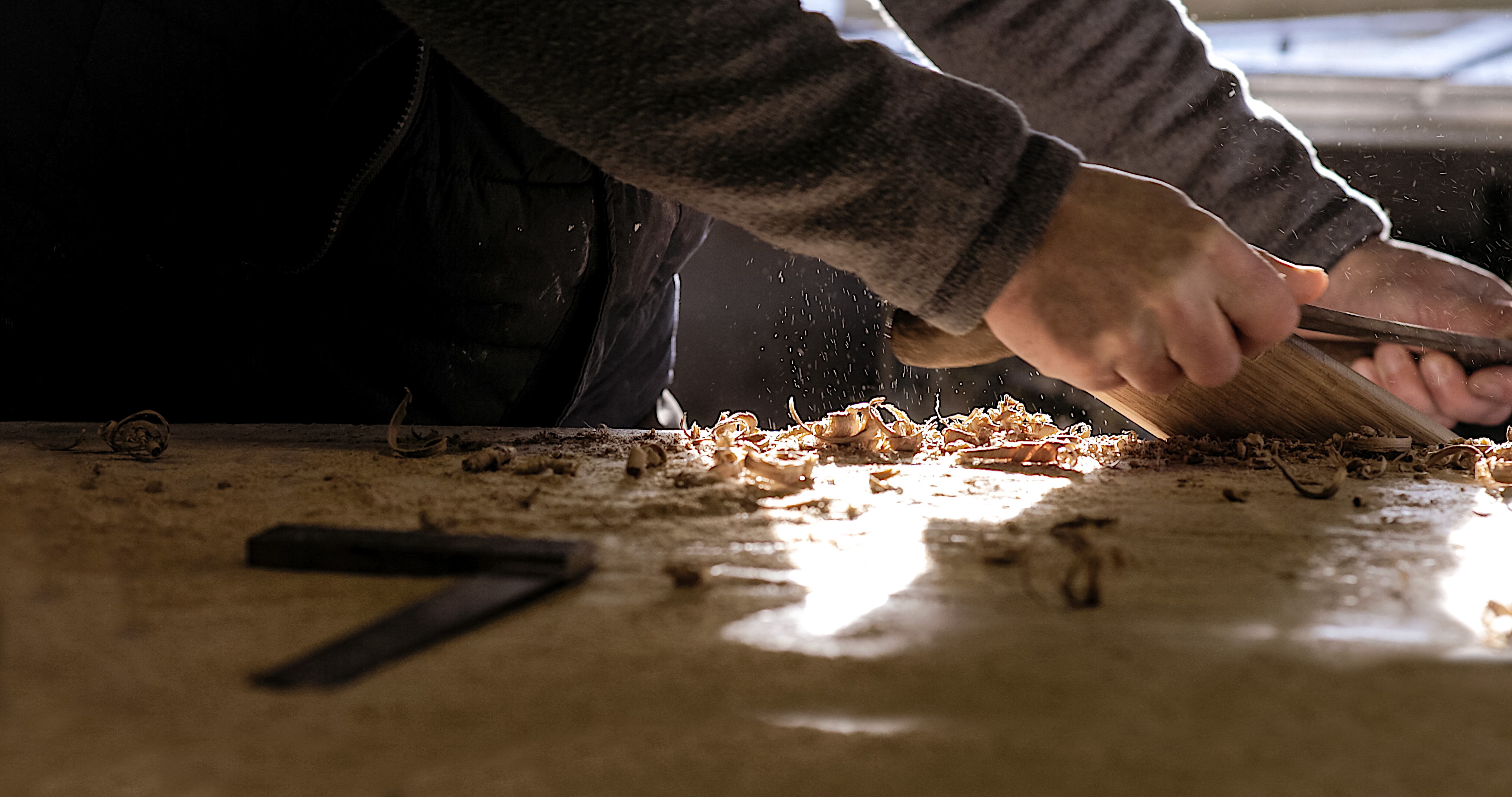 Close up of carpenter&#039;s hands with light from the window.