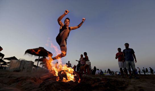 VALENCIA, Un joven salta una hoguera, como manda la tradición, esta noche en la playa de la Malvarrosa de Valencia, donde cada noche de San Juan miles de personas se acercan hasta la orilla del mar para saltar sobre el fuego y las olas.