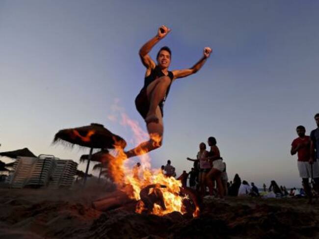 VALENCIA, Un joven salta una hoguera, como manda la tradición, esta noche en la playa de la Malvarrosa de Valencia, donde cada noche de San Juan miles de personas se acercan hasta la orilla del mar para saltar sobre el fuego y las olas.