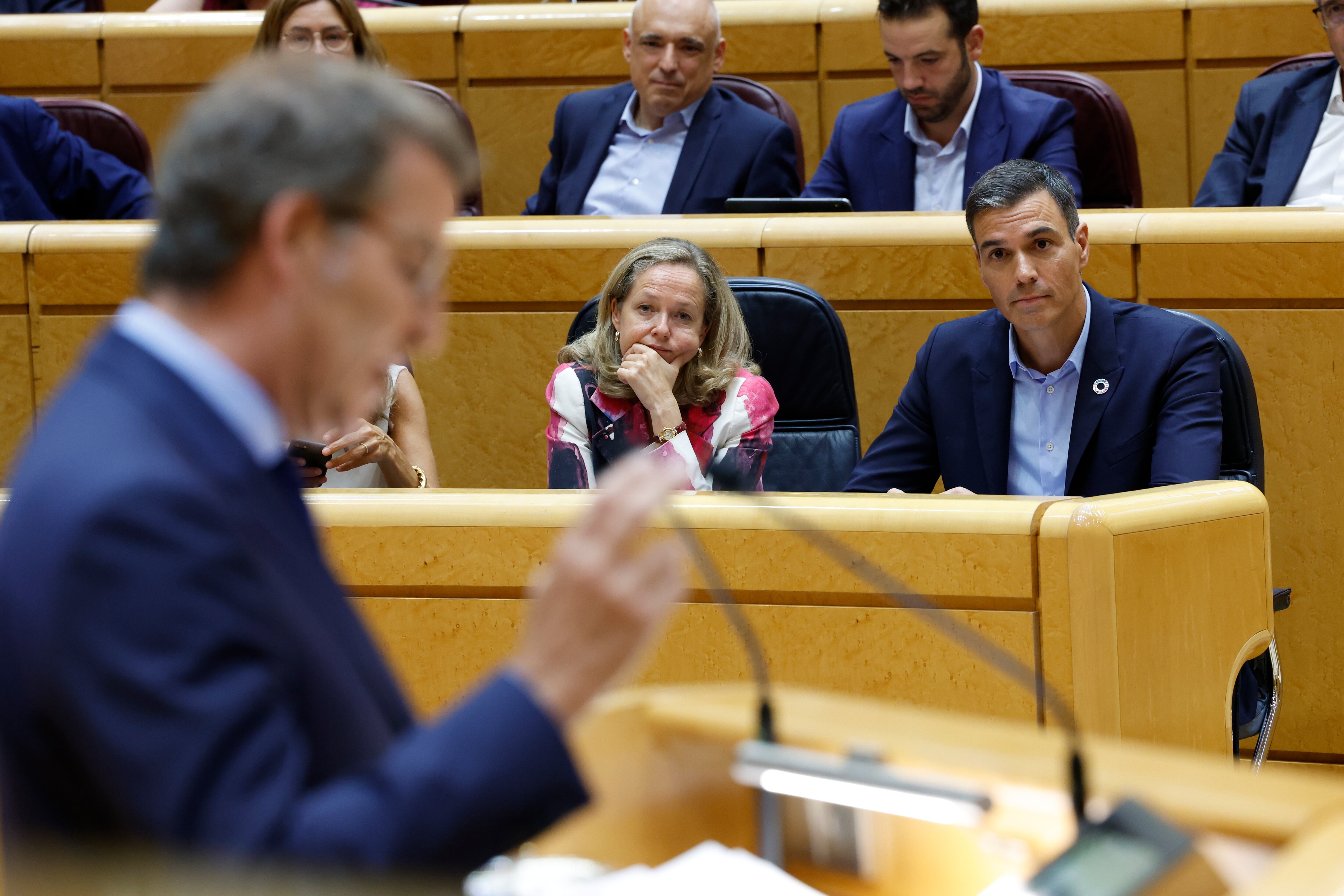 El presidente del Gobierno, Pedro Sánchez (d), y la vicepresidenta primera y ministra de Asuntos Económicos y Transformación Digital, Nadia Calviño (c), escuchan la intervención del líder del PP, Alberto Núñez Feijóo (i), durante el pleno del Senado celebrado este martes en Madrid