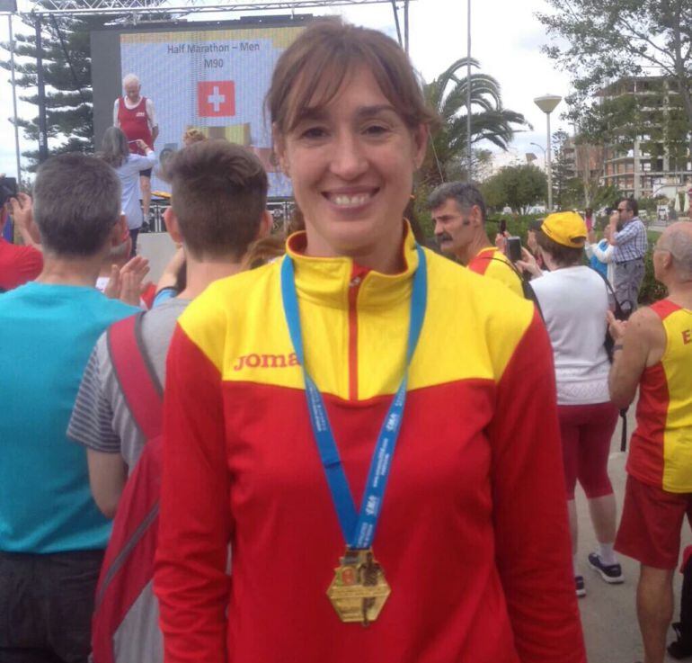 La atleta posa sonriente con su medalla de oro