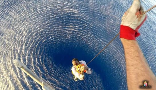 A migrant is rescued by an Italian Navy helicopter in the area where his boat sank in the Mediterranean Sea in this August 11, 2015 handout courtesy of the Italian Navy. Up to 50 migrants went missing after a large rubber dinghy sank in the Mediterranean 