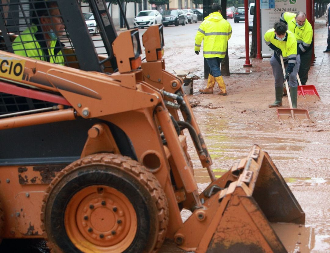 Personal de limpieza del Ayurtamiento de Alzira (Valencia) trabando hoy en el centro de la población tras la tromba de agua que cayó ayer y que dejó un registro de 250 litros por metro cuadrado inundando bajos y cortando carreteras