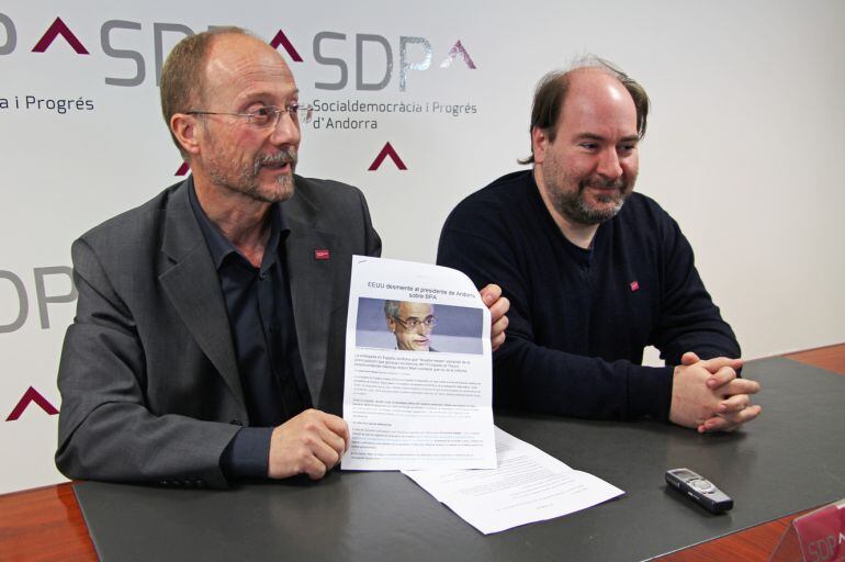 Naudi al costat de Miralles mostra l'article d'EconomiaDigital que recull les declaracions del delegat econòmic de l'ambaixada americana en les que assegurava que Andorra estava alertada abans del 4 de març de les males pràctiques a BPA