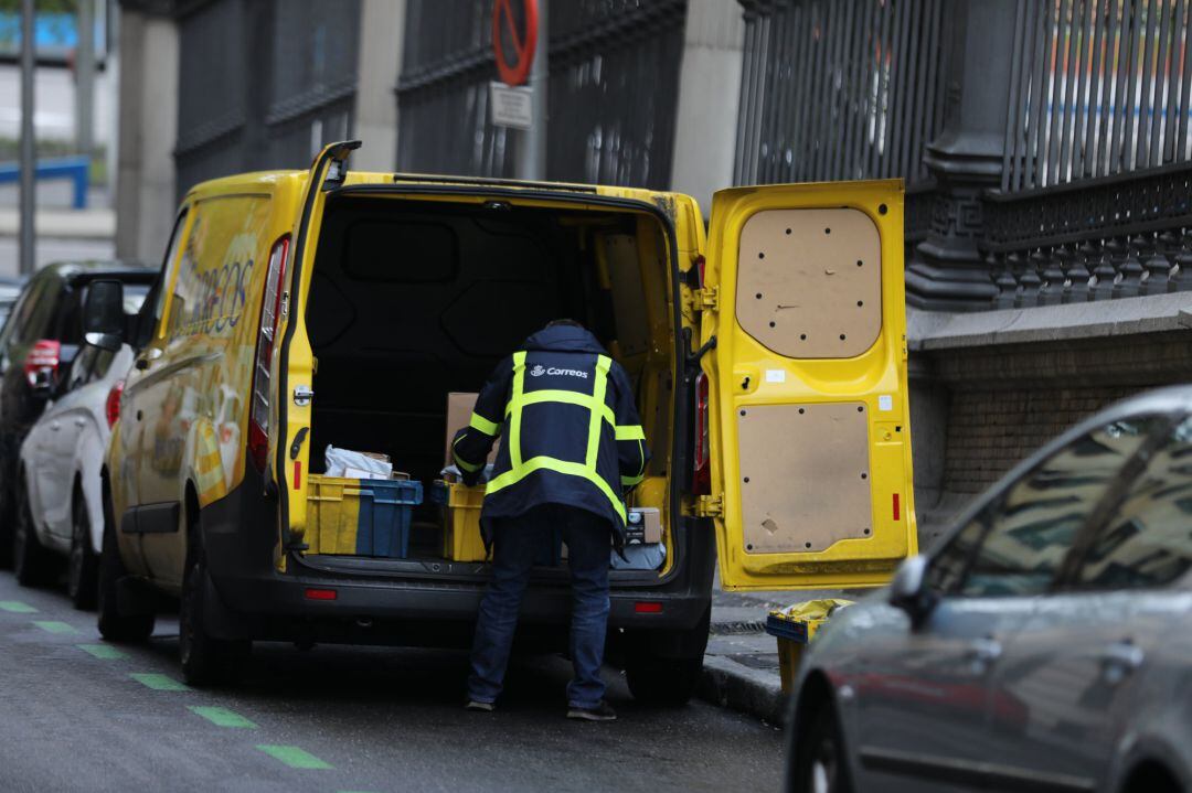 Un trabajador de Correos extrae de su furgoneta paquetes y cartas al inicio del segundo mes del estado de alarma 