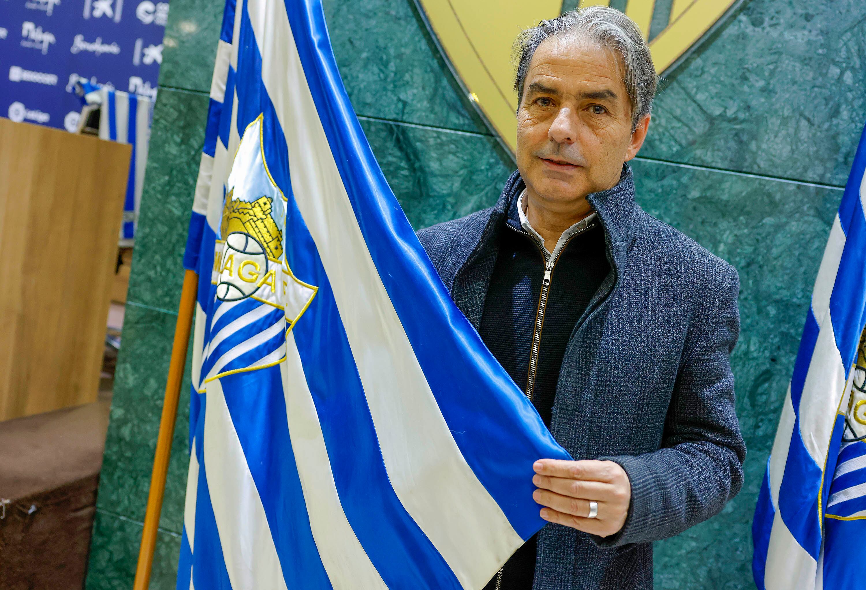 El entrenador Natxo González posa con la bandera del Málaga en su presentación