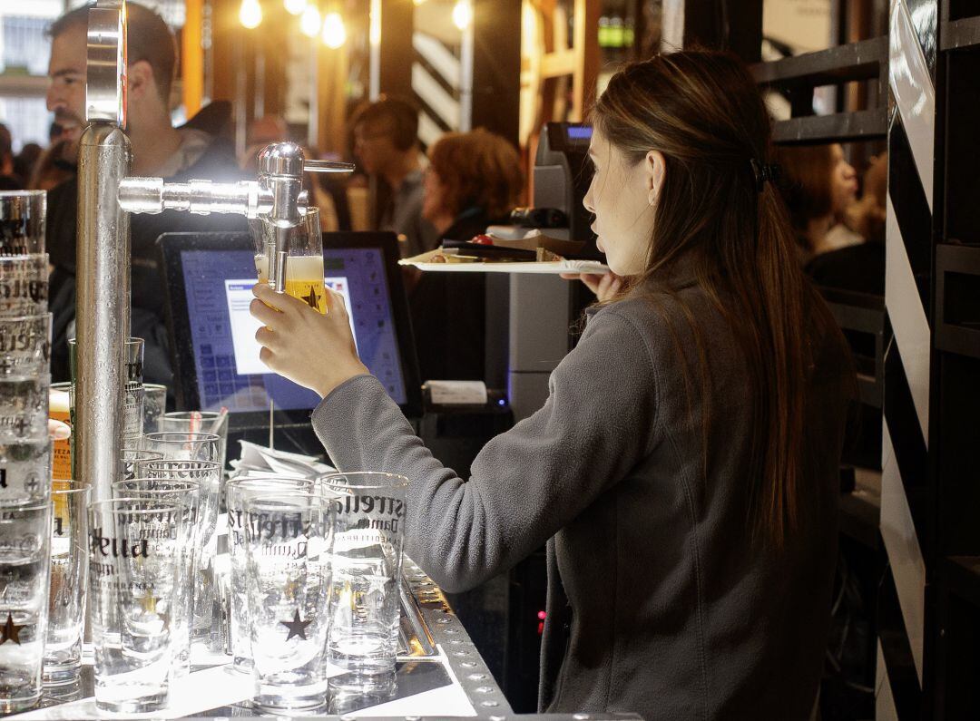 Una camarera tira una cerveza en un bar de Madrid.