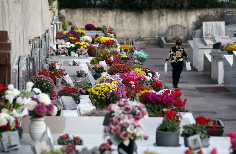 Vista de varias tumbas con flores en la vísepra del día de Todos los Santos 