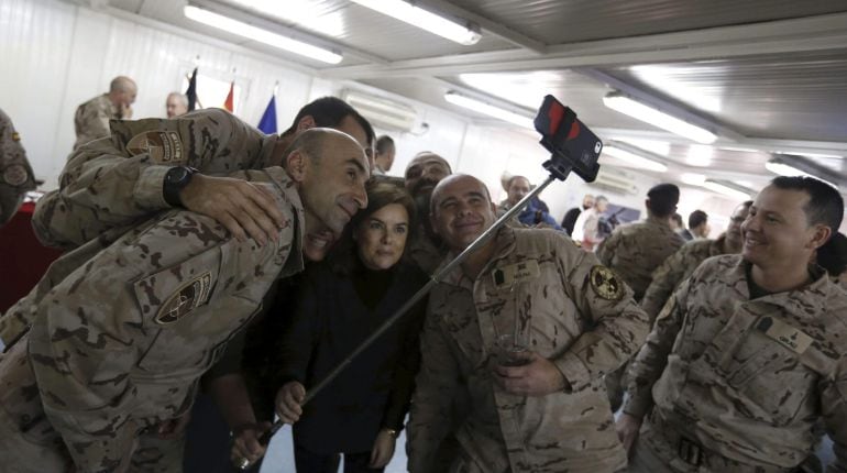 GRA021 HERAT (Afganistan), 15/12/2014.- La vicepresidenta del Gobierno, Soraya Sáenz de Santamaría, se hace un autoretrato con varios militares de la Base de Herat donde ha llegado hoy para visitar a las tropas españolas desplegadas en este país, en lo que constituye su primer viaje a una misión en el exterior desde que ocupa el cargo.Este viaje, que se ha mantenido en secreto hasta ahora por motivos de seguridad, es el primero que realiza a una misión militar en el exterior como vicepresidenta del Gobierno.España tiene actualmente desplegados 464 militares en Afganistán, la mayoría de ellos destinados en la base de Herat, encargados de gestionar el aeropuerto y el hospital Role 2, así como de la protección de la base. EFE/ Javier Lizón