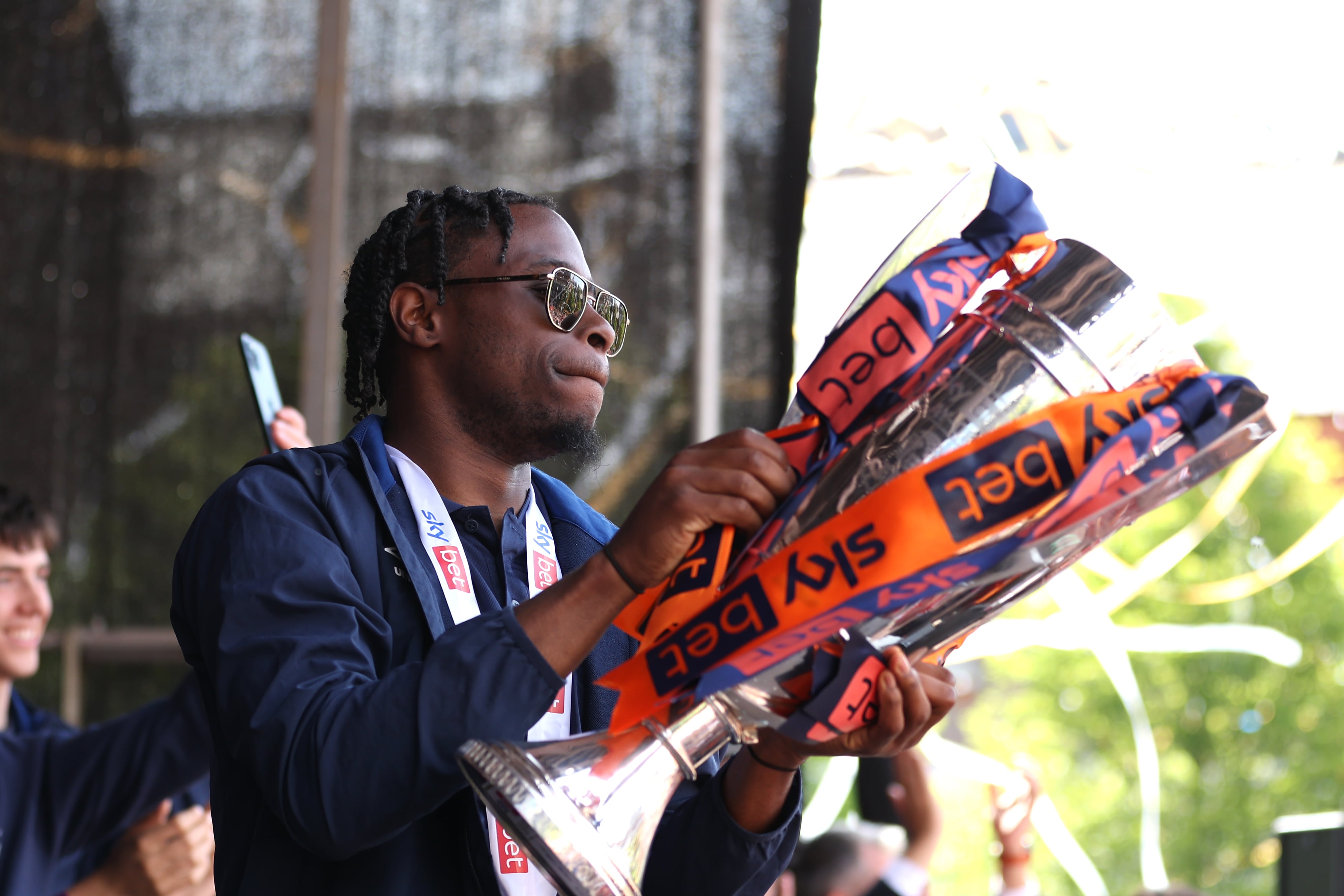 Mpanzu sujetando el trofeo durante la celebración del ascenso del Luton Town a la Premier League.