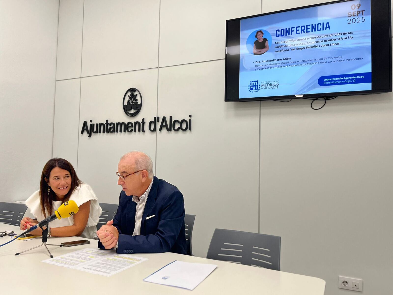 Lorena Zamorano, edil de Turismo, y Hermann Schwarz, presidente del Colegio Oficial de Médicos de Alicante, presentando la conferencia.