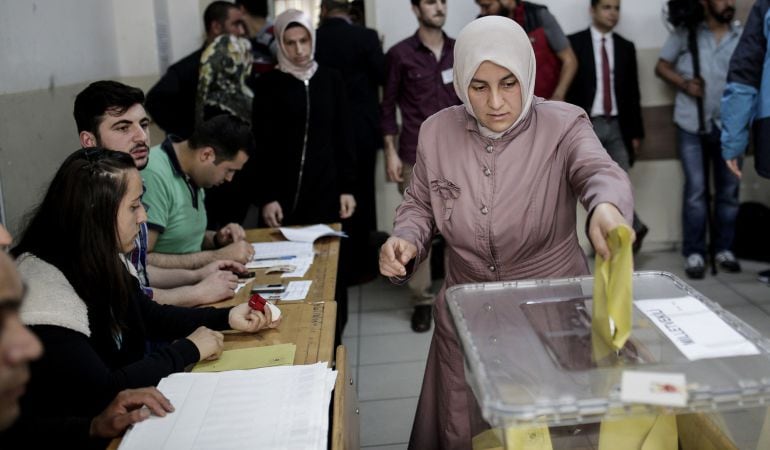 Una mujer turca arroja su voto en un colegio electoral de Estambul para las elecciones legislativas.