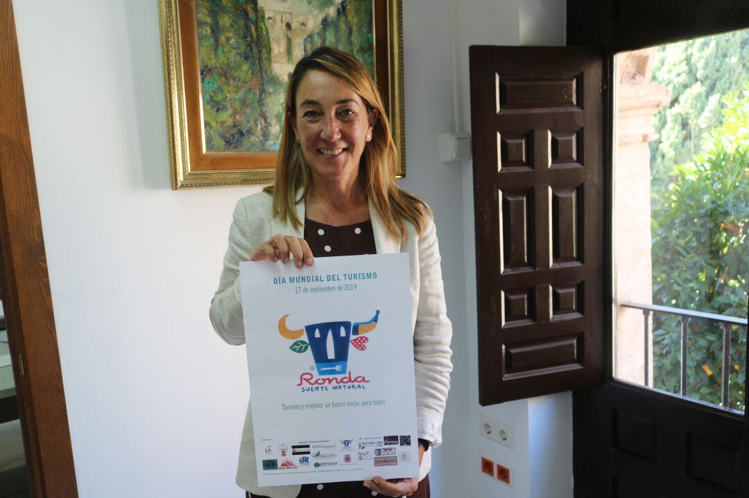 La concejala de Turismo, Alicia López, muestra el cartel anunciador del Día del Turismo