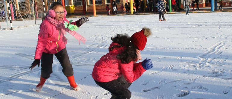 Alumnos del CEIP Ntra Sra de la Piedad de Herrera de Pisuerga, en Palencia, juegan con la nieve antes de entrar en clase