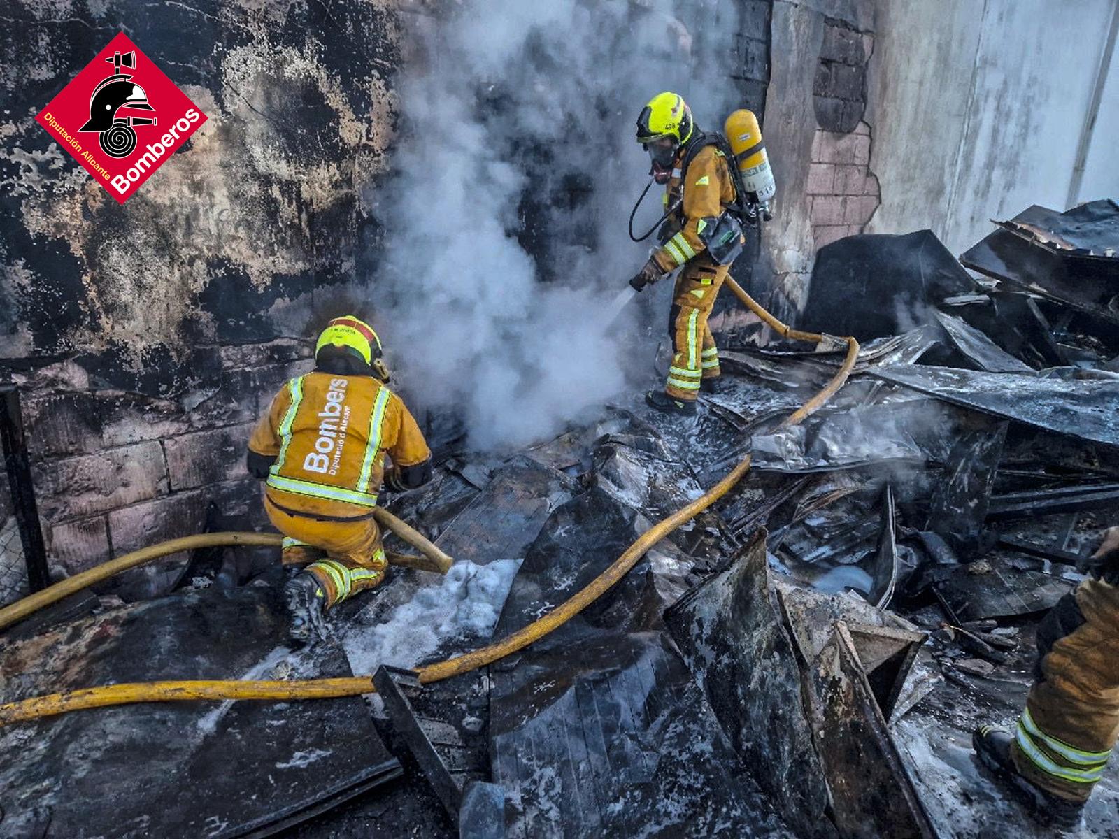 Los bomberos durante la extinción del fuego en una nave industrial en Ibi.