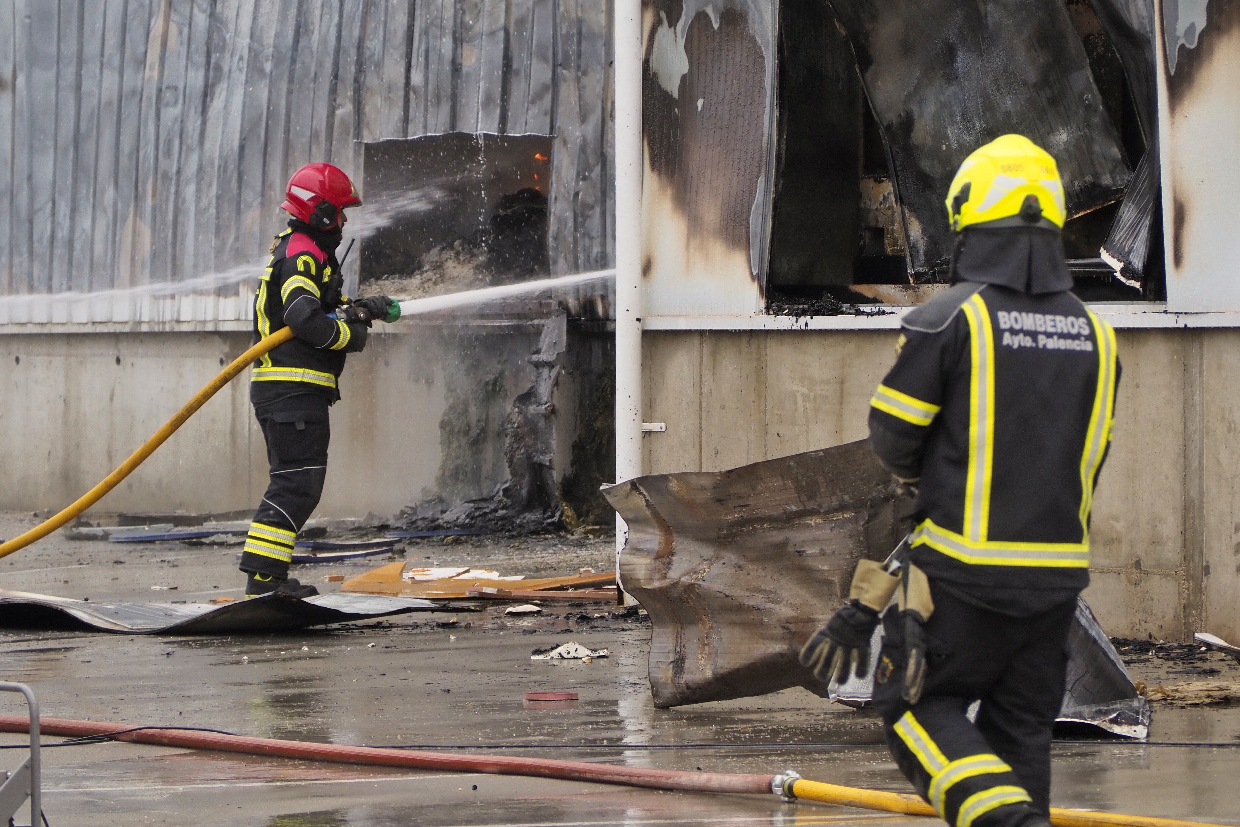 DUEÑAS (PALENCIA), 26/01/2023.- Los bomberos se afanan en apagar los rescoldos de un incendio declarado sobre las 3 de la mañana de este jueves en la fábrica de la empresa Cascajares en Dueñas (Palencia) que ha calcinado por completo las dos naves y es una &quot;auténtica catástrofe&quot; para esta compañía, conocida especialmente por sus capones navideños. EFE/ R. Garcia
