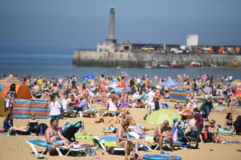 Bañistas disfrutan del sol en una playa. 