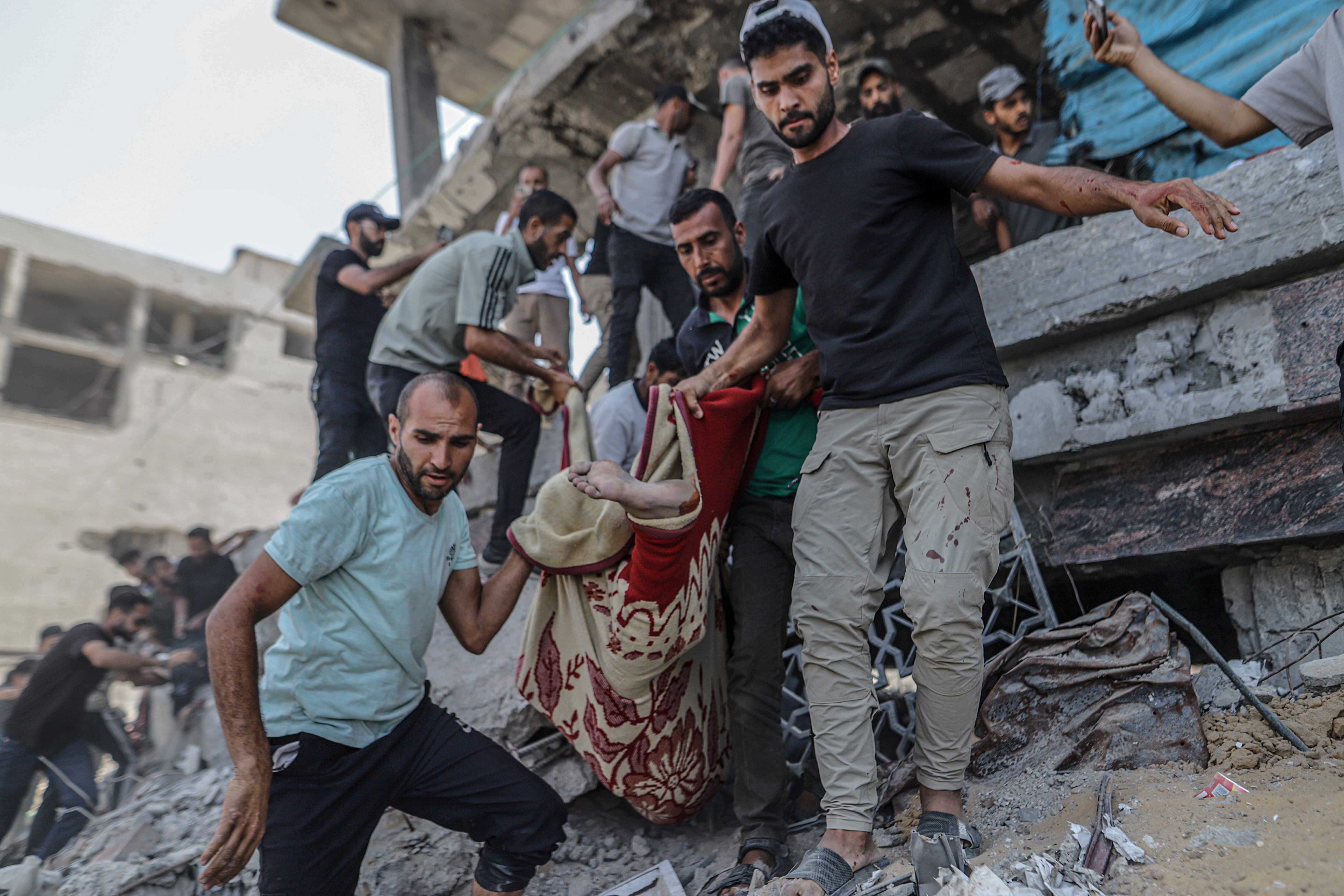 Palestinos recuperan un cuerpo de las ruinas de un edificio en el barrio de Al Remal en Gaza