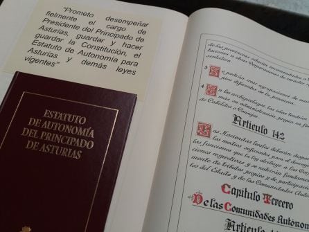 Ejemplares de la Constitución Española y del Estatuto de Autonomía reposan sobre el atril en el que Barbón prometió su cargo