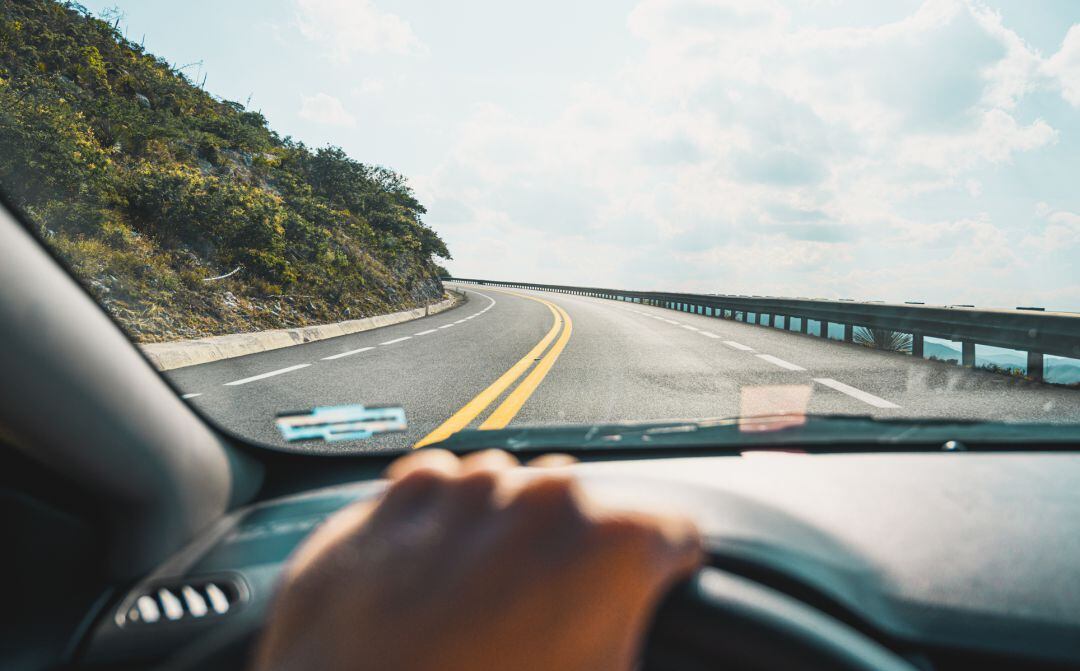 Una persona conduciendo por la carretera con su vehículo.